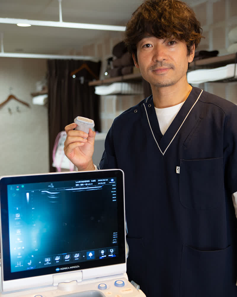 エコーを使って腰の状態を確認する院長